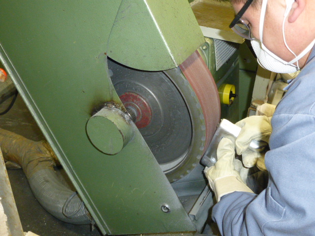 Schleifmaschine für die Nachbearbeitung von Druckgussteilen Mitarbeiter beim Schleifen und Glätten von Zinkdruckgussteilen bei DRUTEC